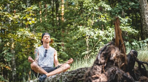  a man doing meditation outdoors to experience the nature with mindfulness