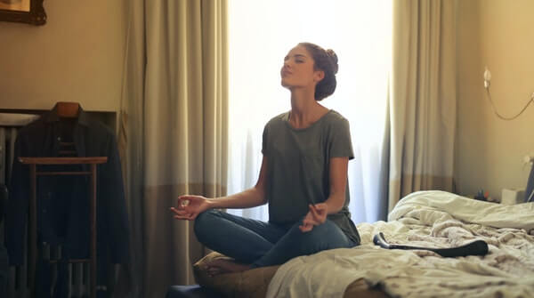 a woman meditating at her home