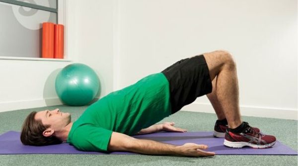 Man doing glute bridge exercise. It helps relieve stress from the nervous sytstem. Also works on back and leg muscles