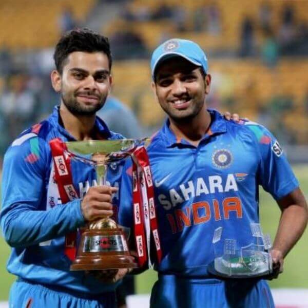 Indian batsmen Kohli and Sharma holding trophies after defeating Australia in 7th ODI
