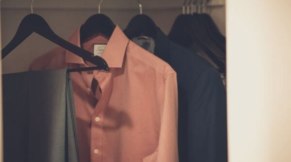 Perfect formal shirts and a trouser  to make a complete formal dress code for interview. They are hanging in a closet.